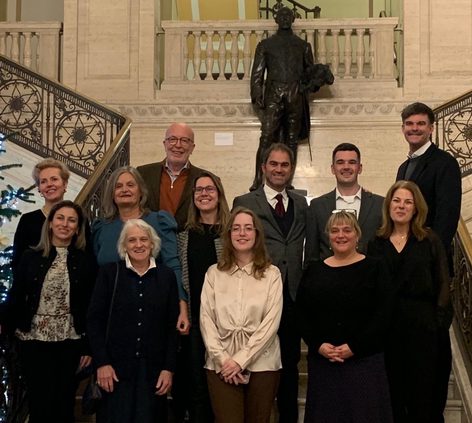 A group of people standing on a staircase in front of a black statue