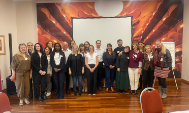 A group of people standing together and smiling at the camera