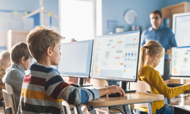 A boy in a classroom is using a computer