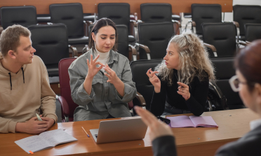 A group of young people communicate using sign language